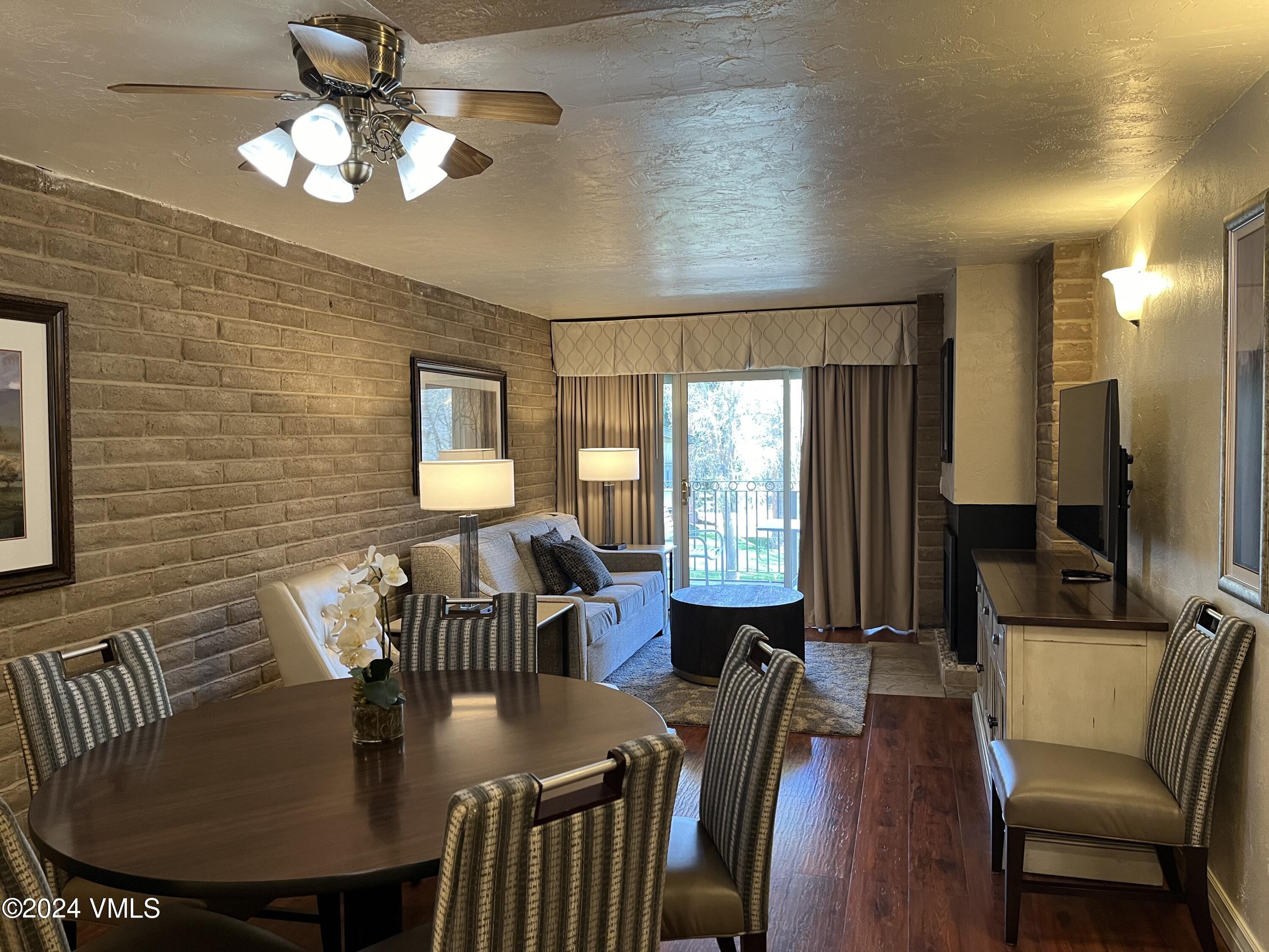 a view of a a dining room with furniture window and wooden floor