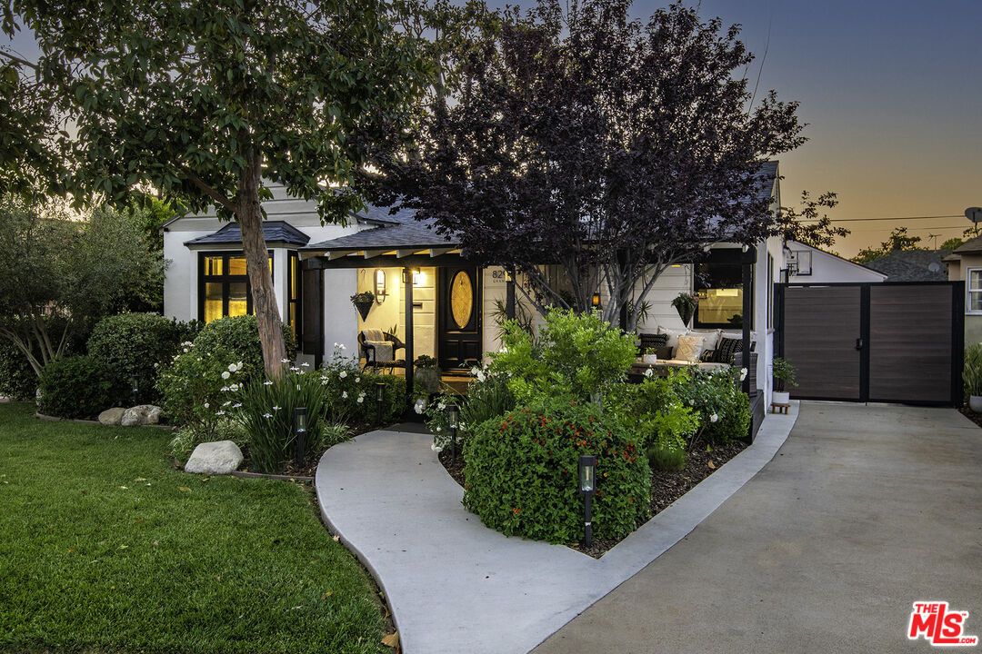 a front view of a house with a yard and trees