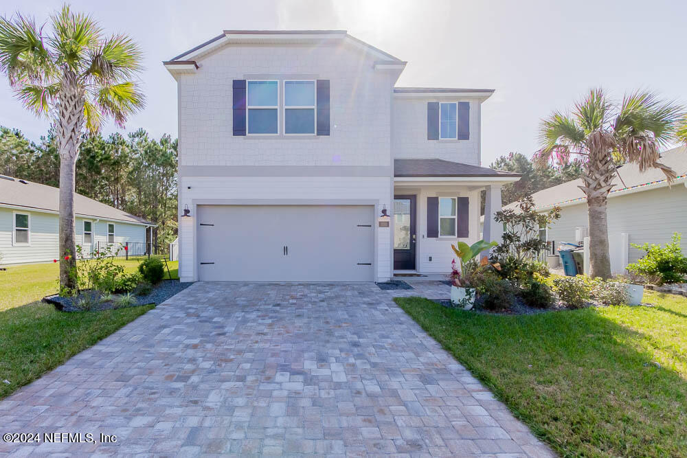 a front view of a house with a yard and a garage