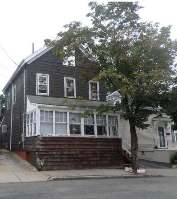 a front view of a house with a tree