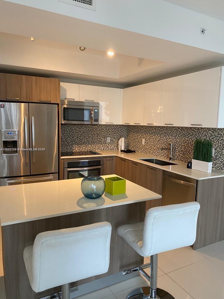 a kitchen with a table chairs and a refrigerator