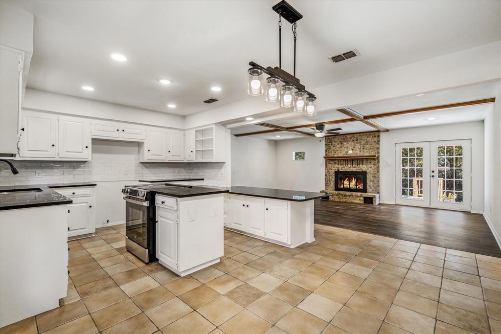 a kitchen with stainless steel appliances granite countertop a sink a stove and a refrigerator