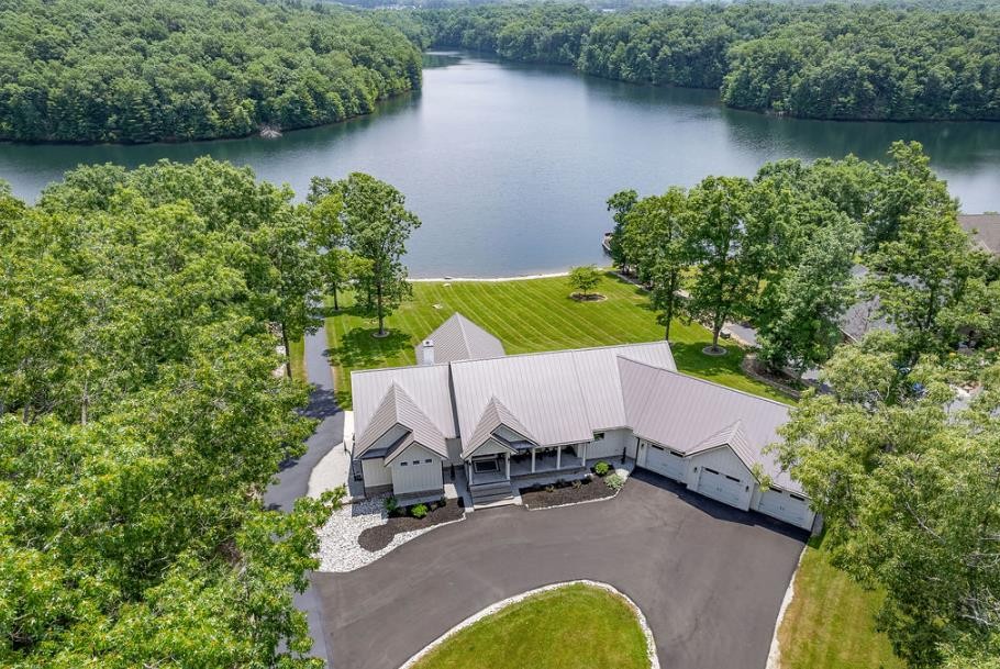 an aerial view of a house with swimming pool and lake view