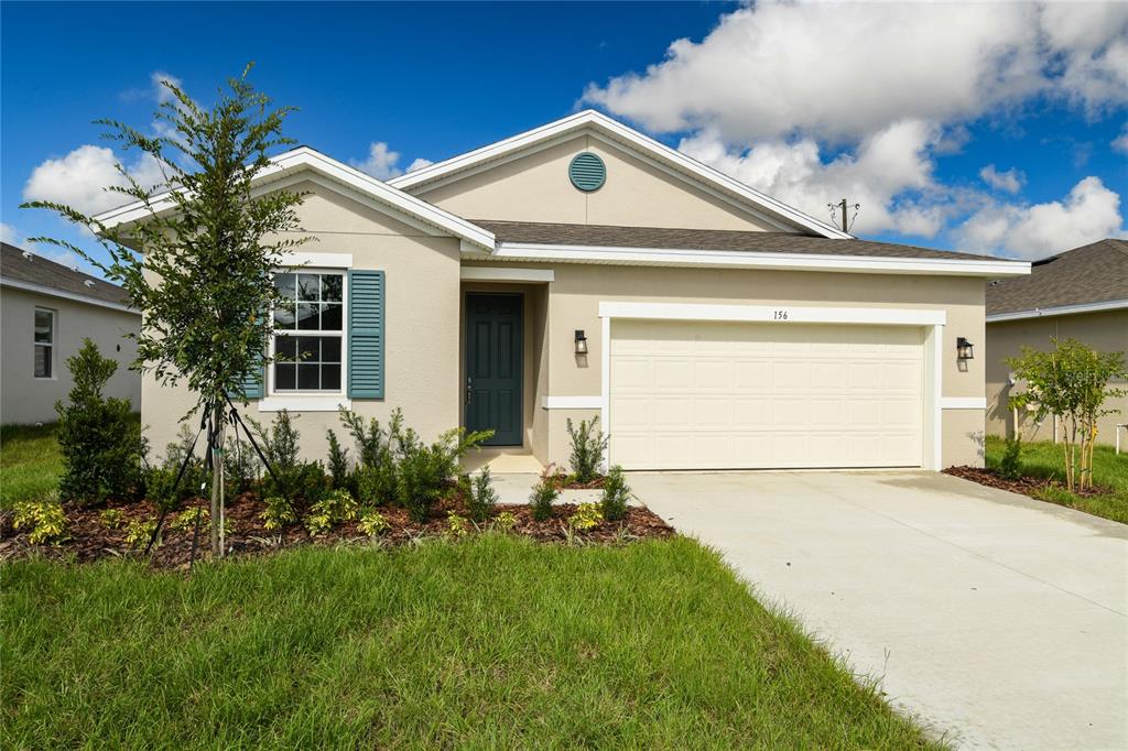 a front view of a house with a yard and garage