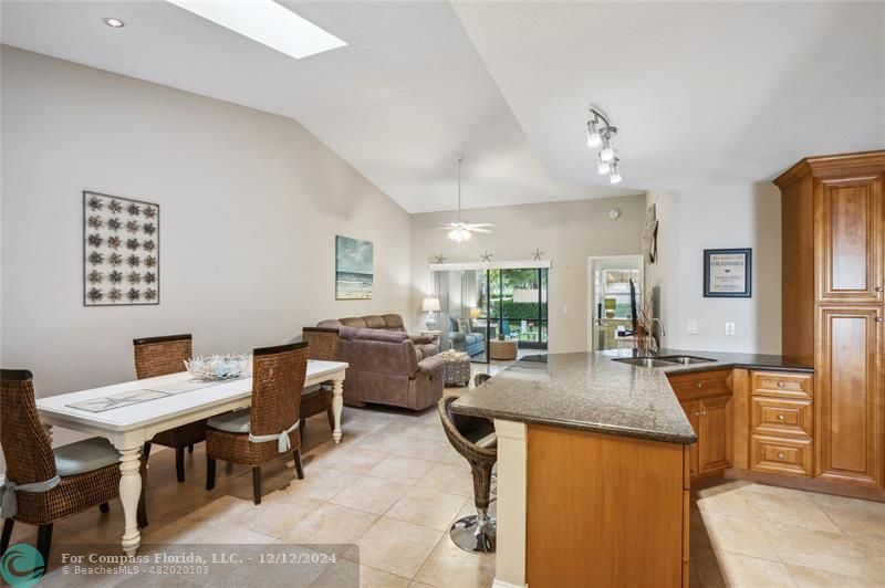 a living room with furniture a large window and kitchen view