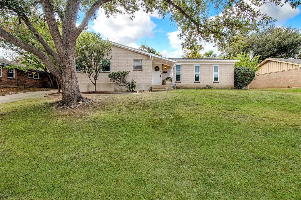 a view of a house with backyard and a tree