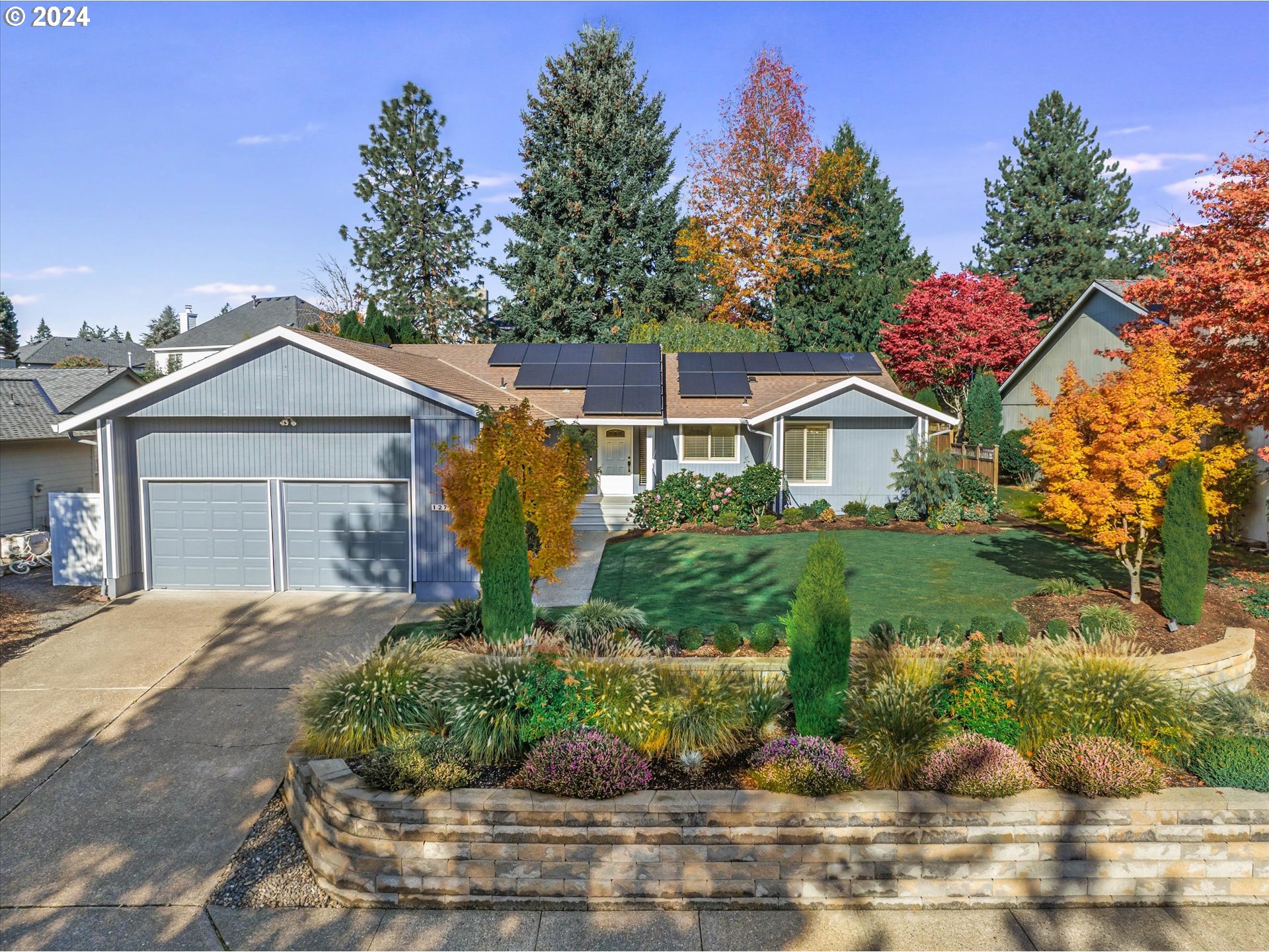 a front view of a house with a yard and potted plants