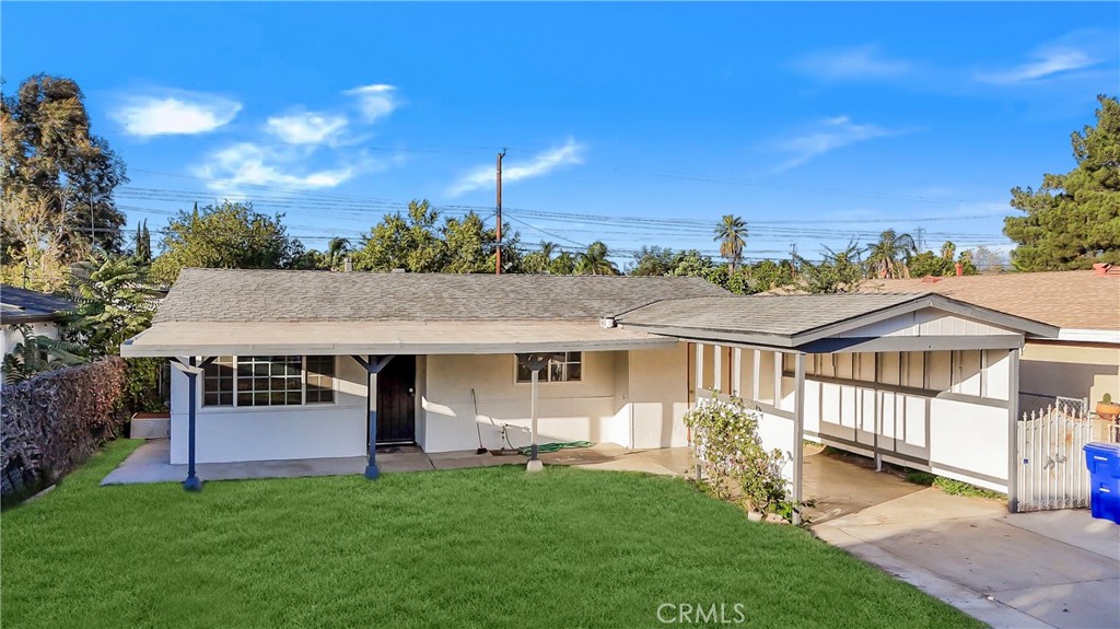 a view of a house with a big yard plants and large trees