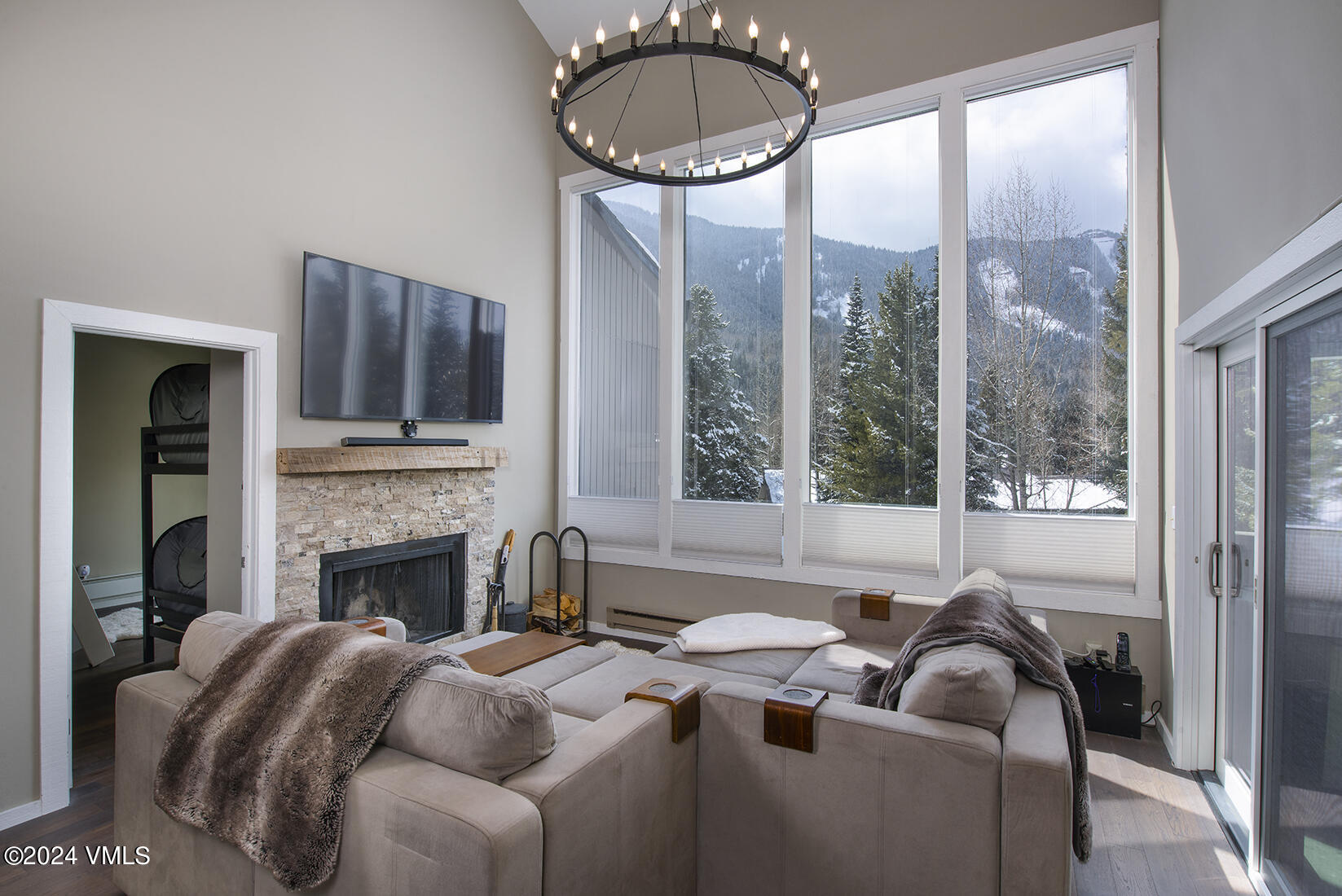 a living room with furniture a fireplace and a floor to ceiling window