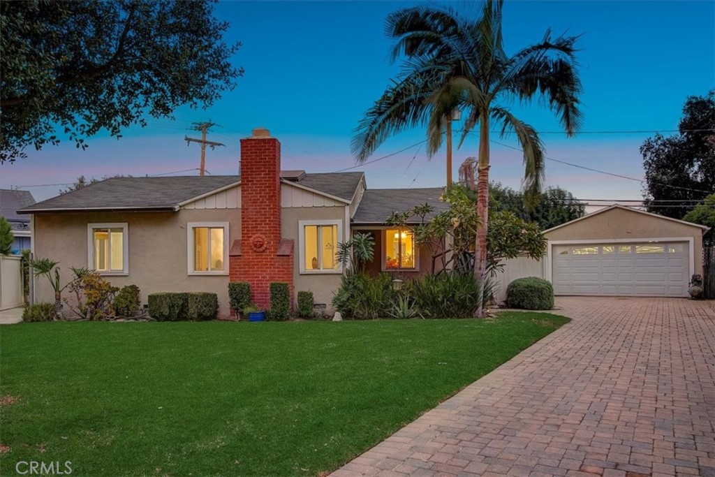 a front view of a house with a garden and yard