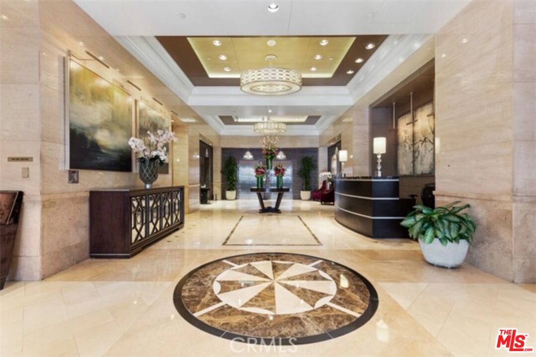 a view of a hallway with a dining table and chandelier