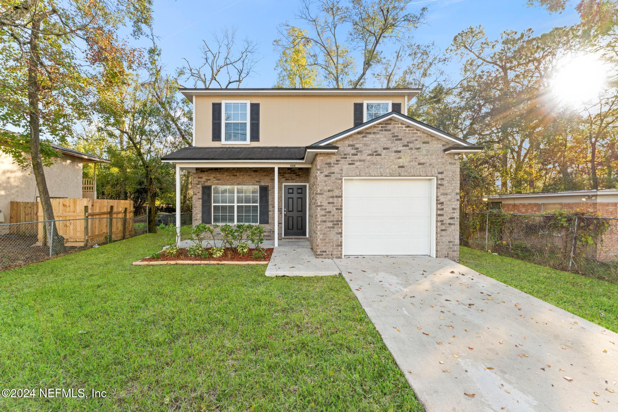 a front view of a house with a yard and garage