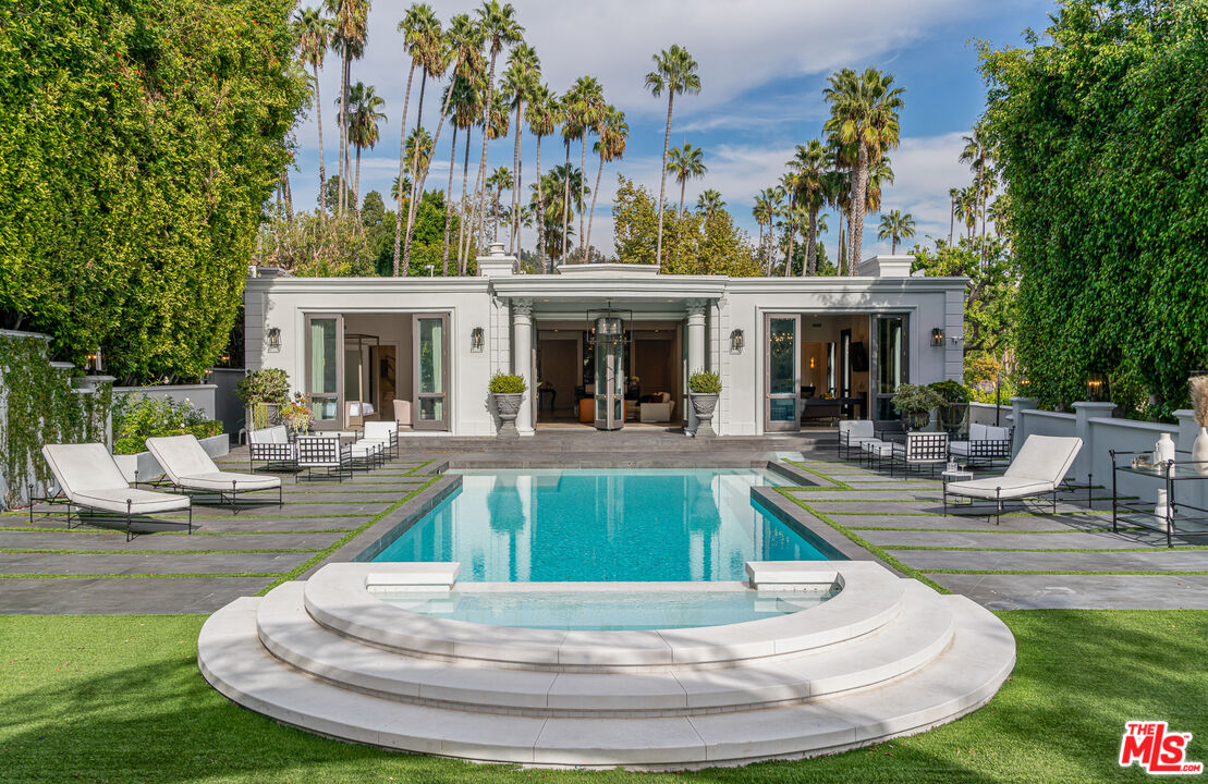 a view of a house with swimming pool and sitting area