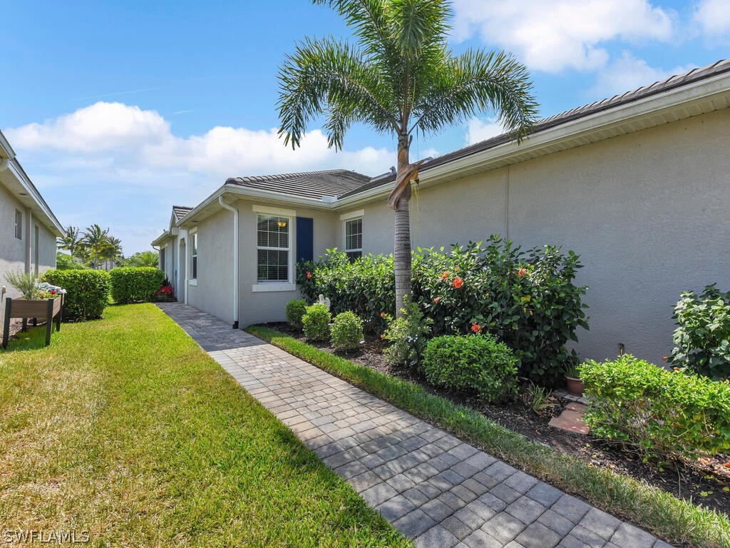 a view of a house with a yard and palm trees