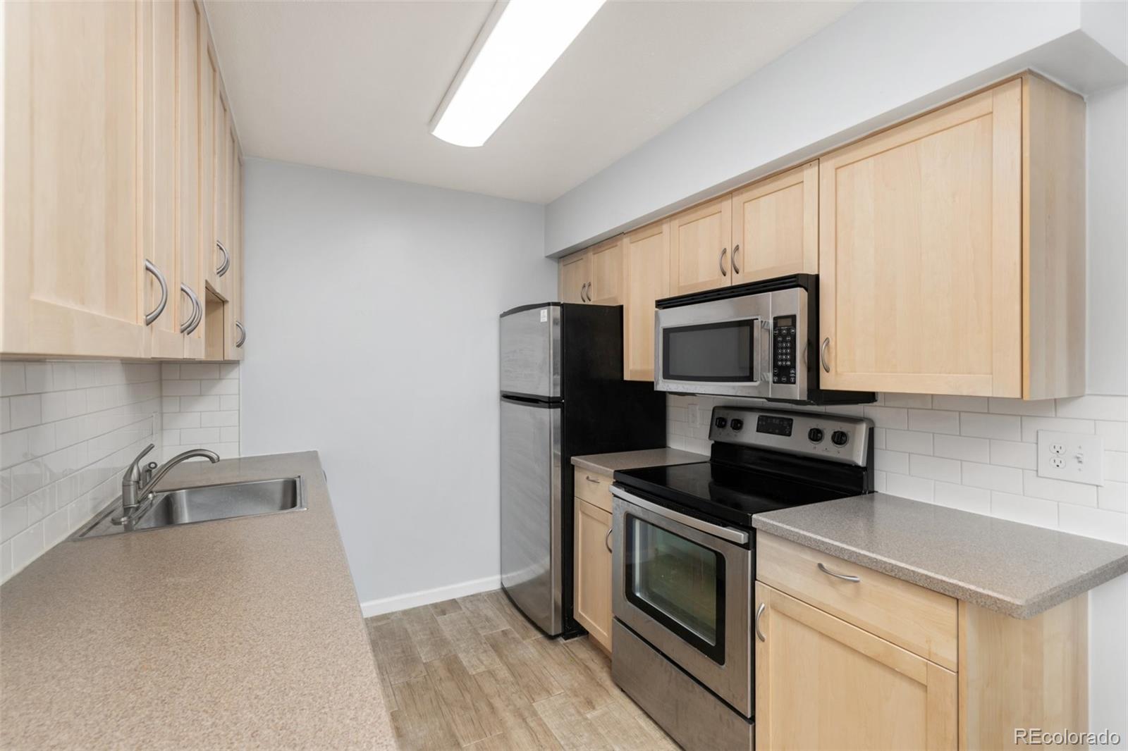 a kitchen with stainless steel appliances white cabinets and a stove top oven