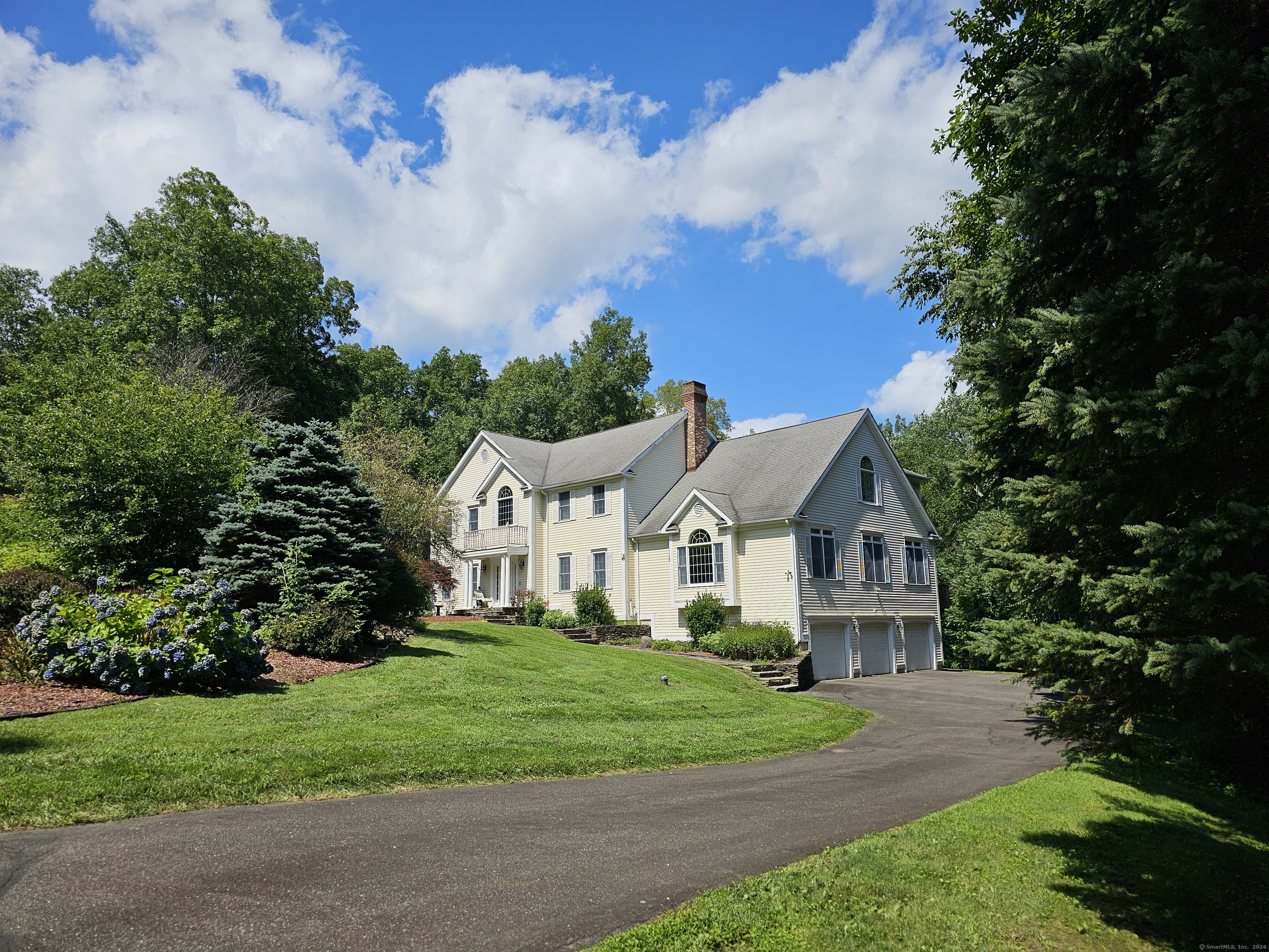 a front view of a house with a yard and trees