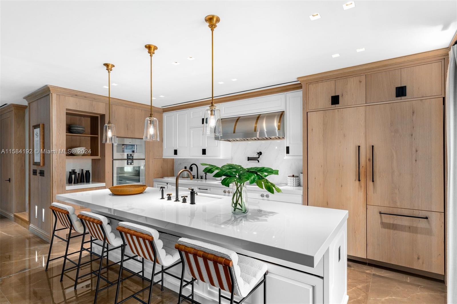 a kitchen with stainless steel appliances a dining table chairs and refrigerator