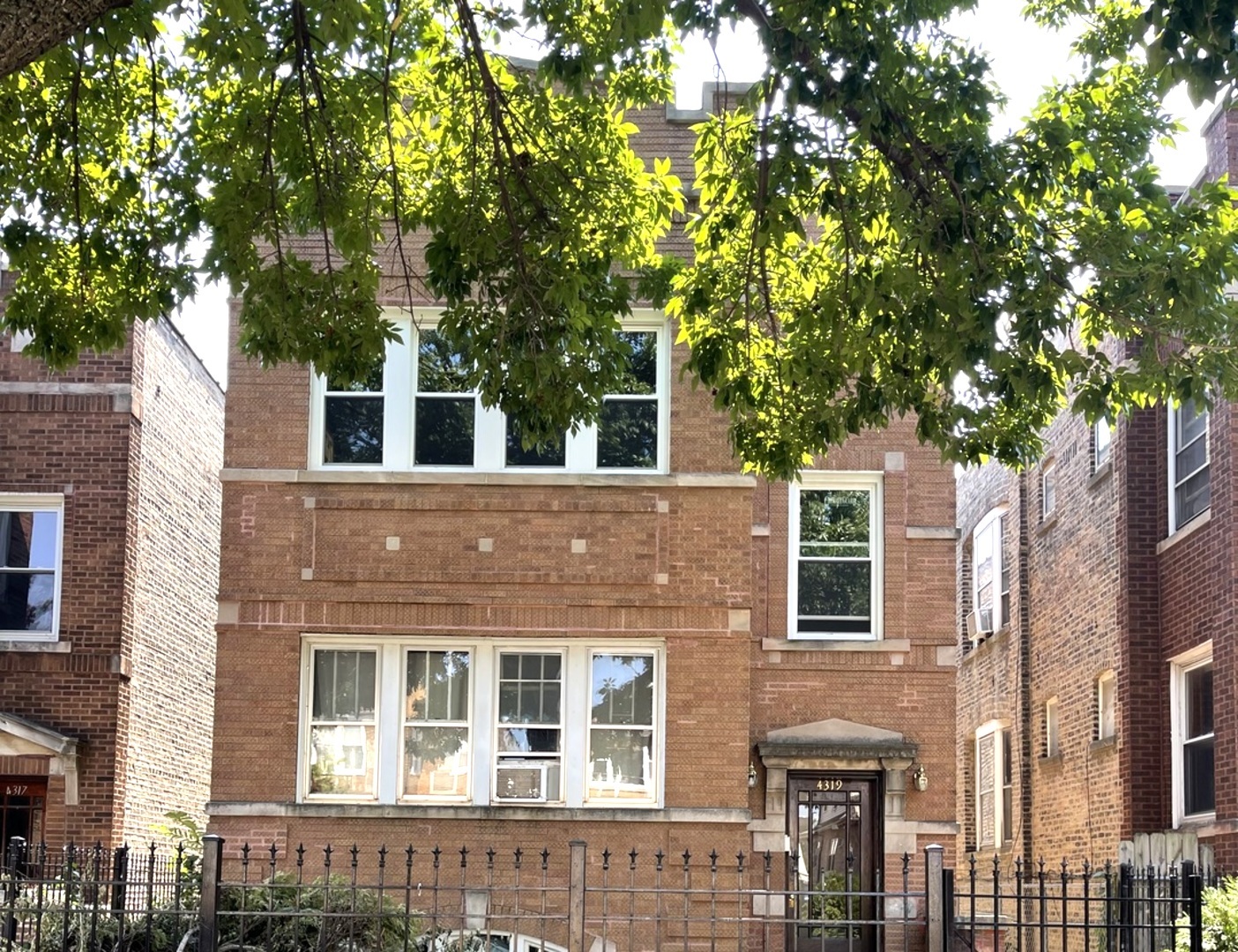 a front view of a house with a tree