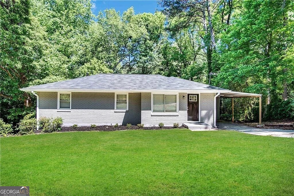 a front view of house with a garden and trees