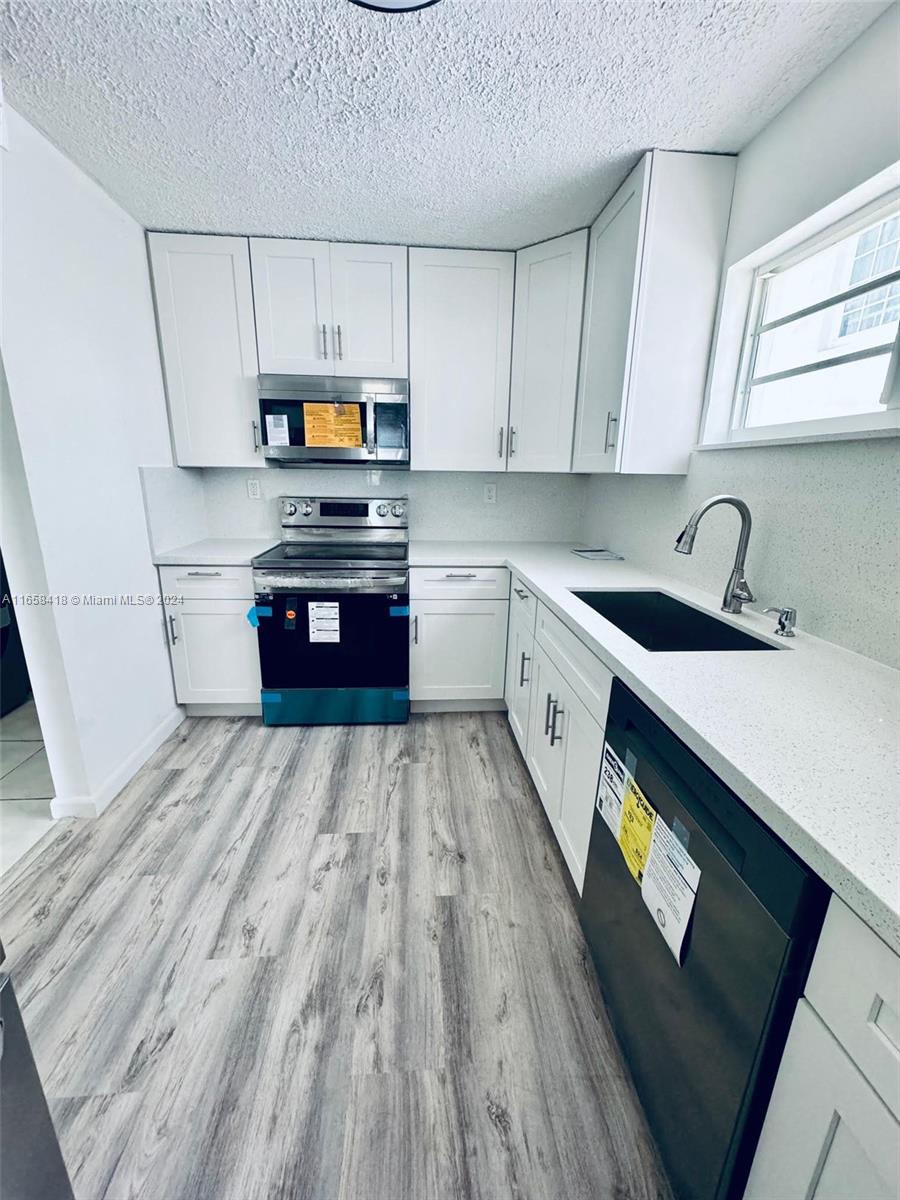 a kitchen with a sink a stove and cabinets