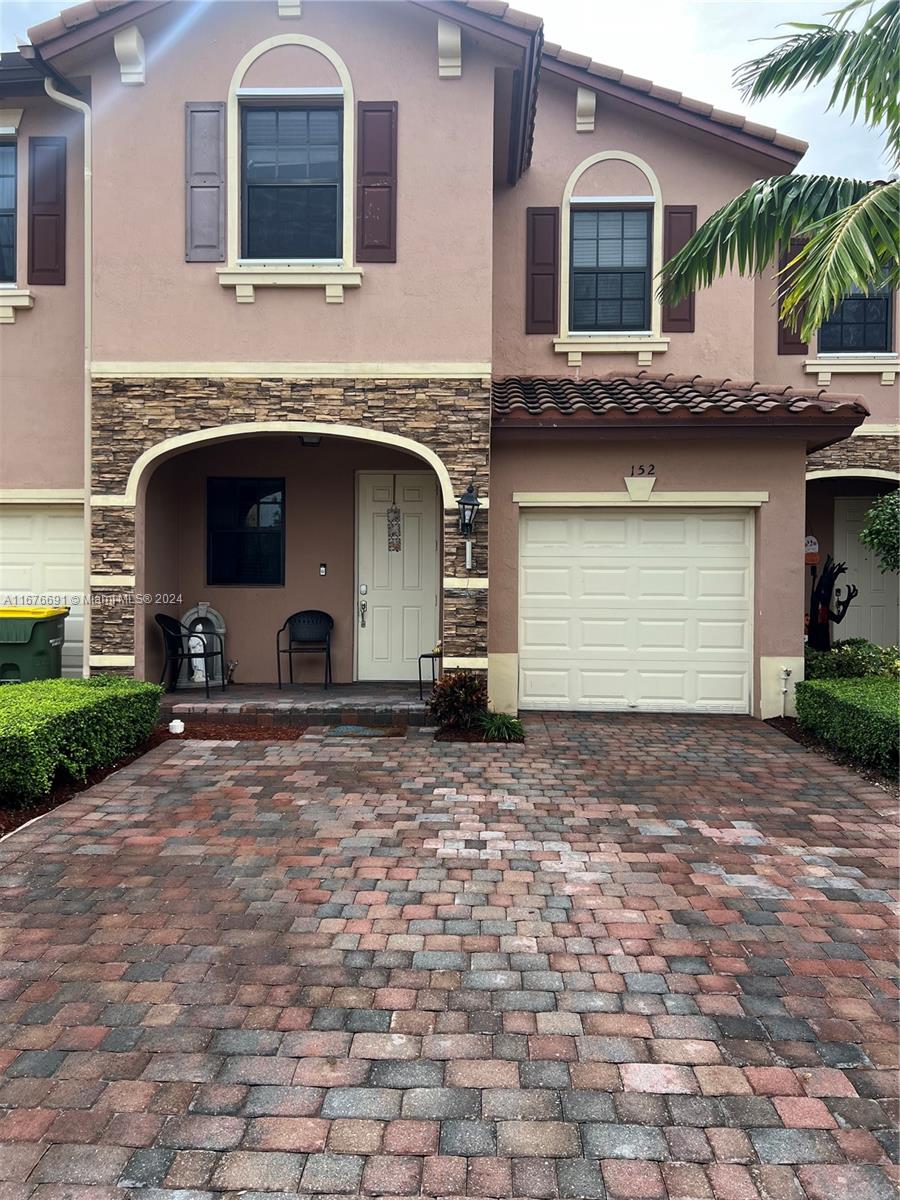 a front view of a house with a yard and garage