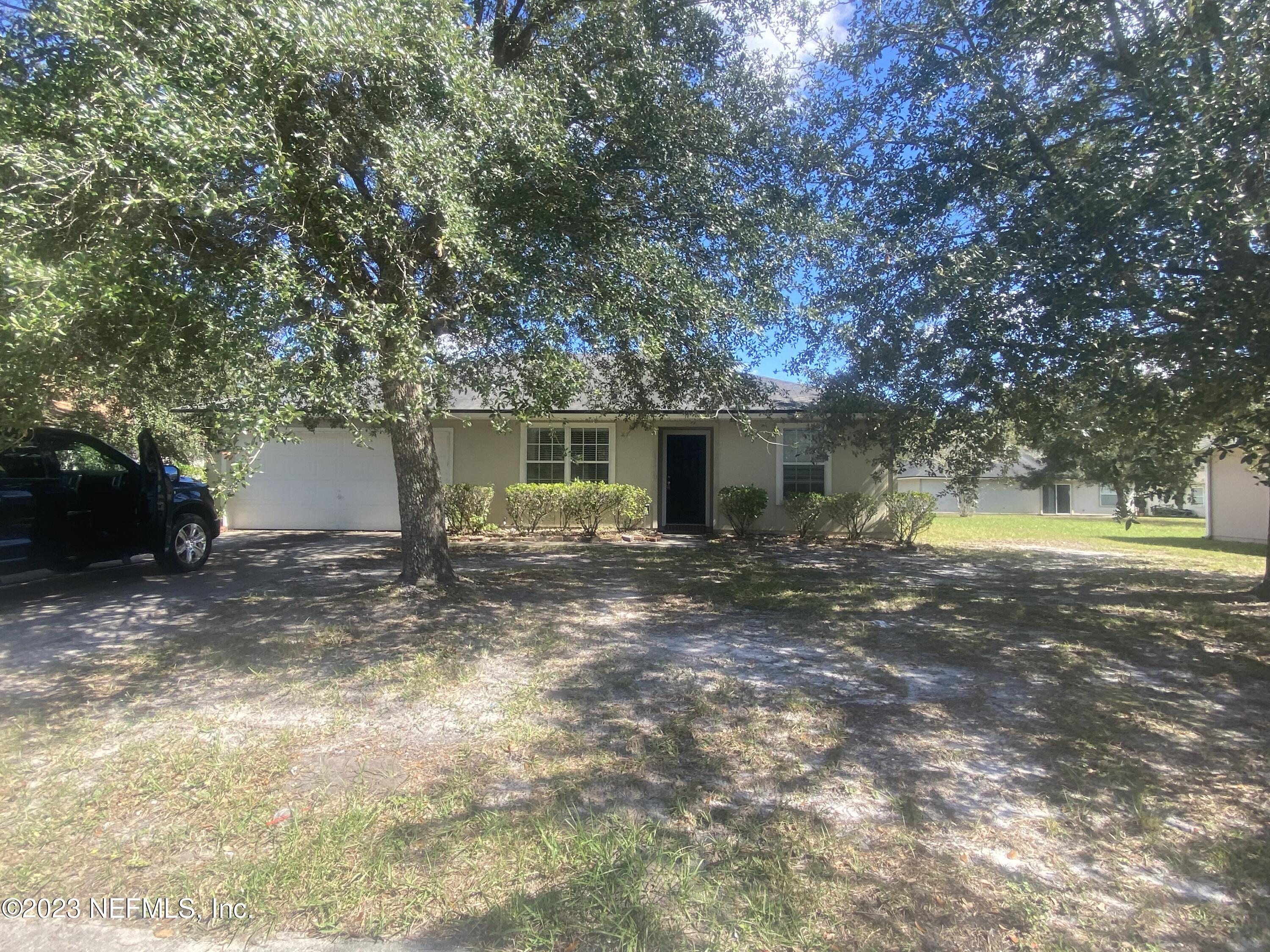 a view of a house with a yard and tree