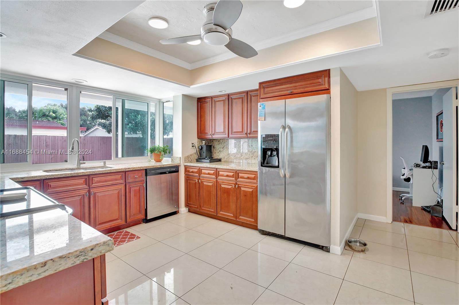 a kitchen with stainless steel appliances granite countertop a refrigerator and a sink