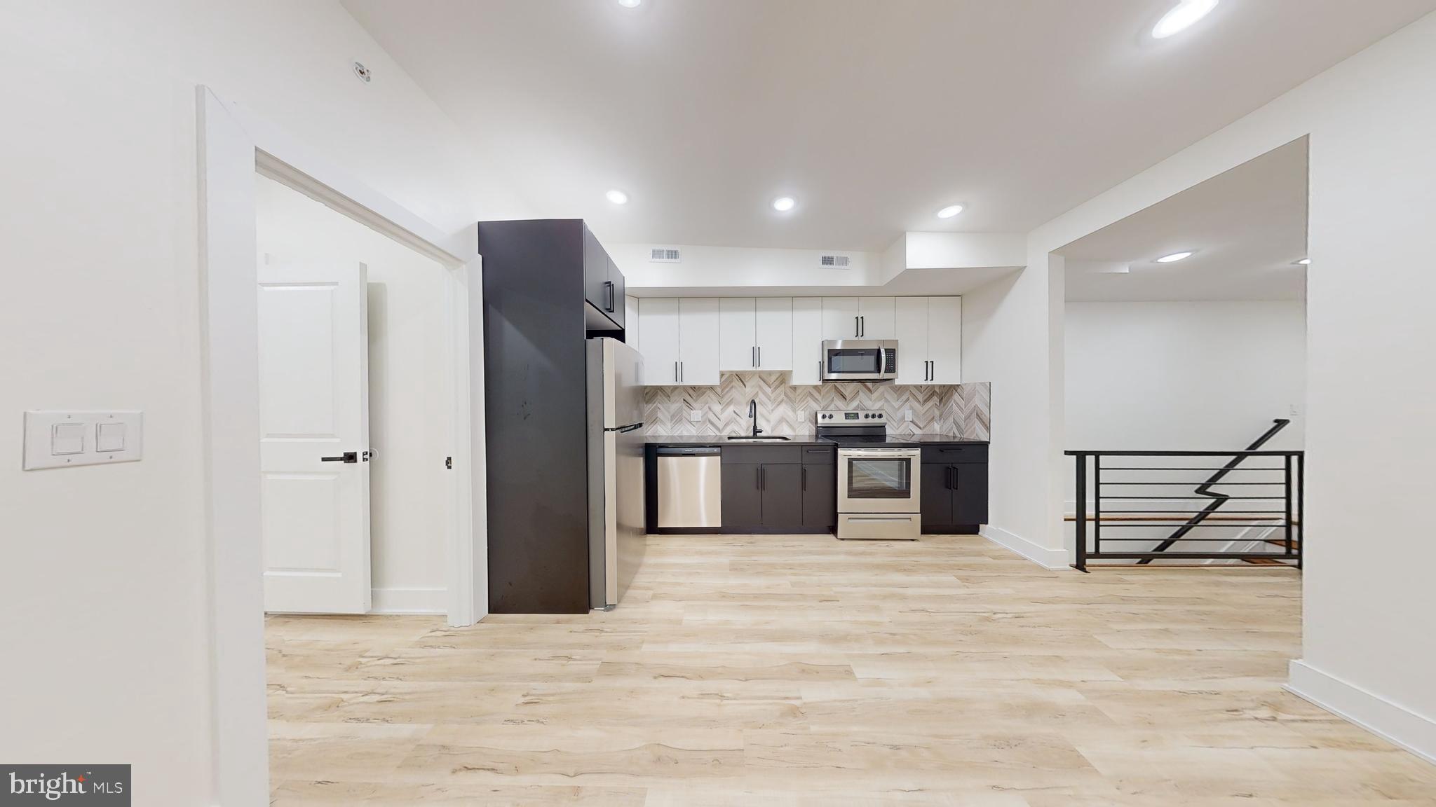 a kitchen with stainless steel appliances kitchen island granite countertop a refrigerator and a sink