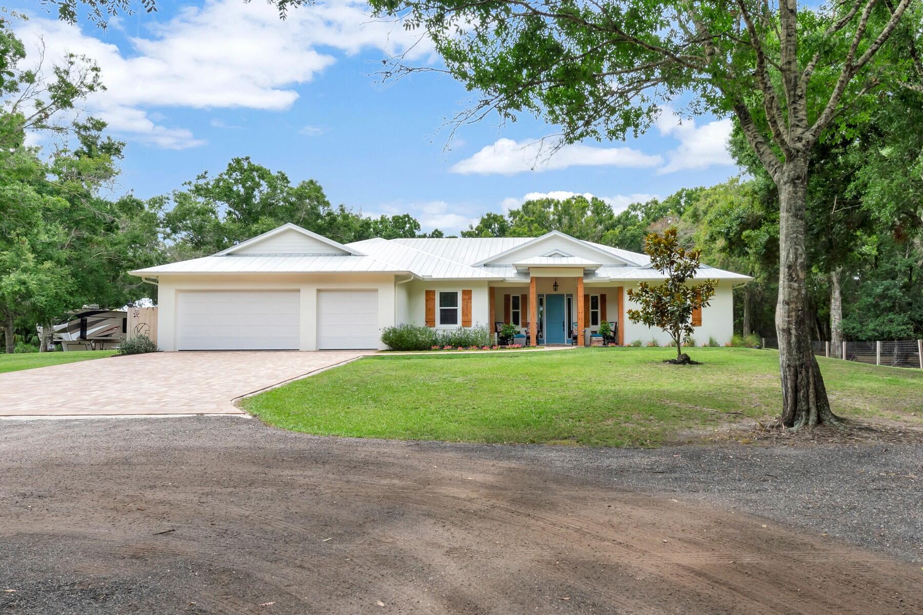 a front view of a house with a yard and trees