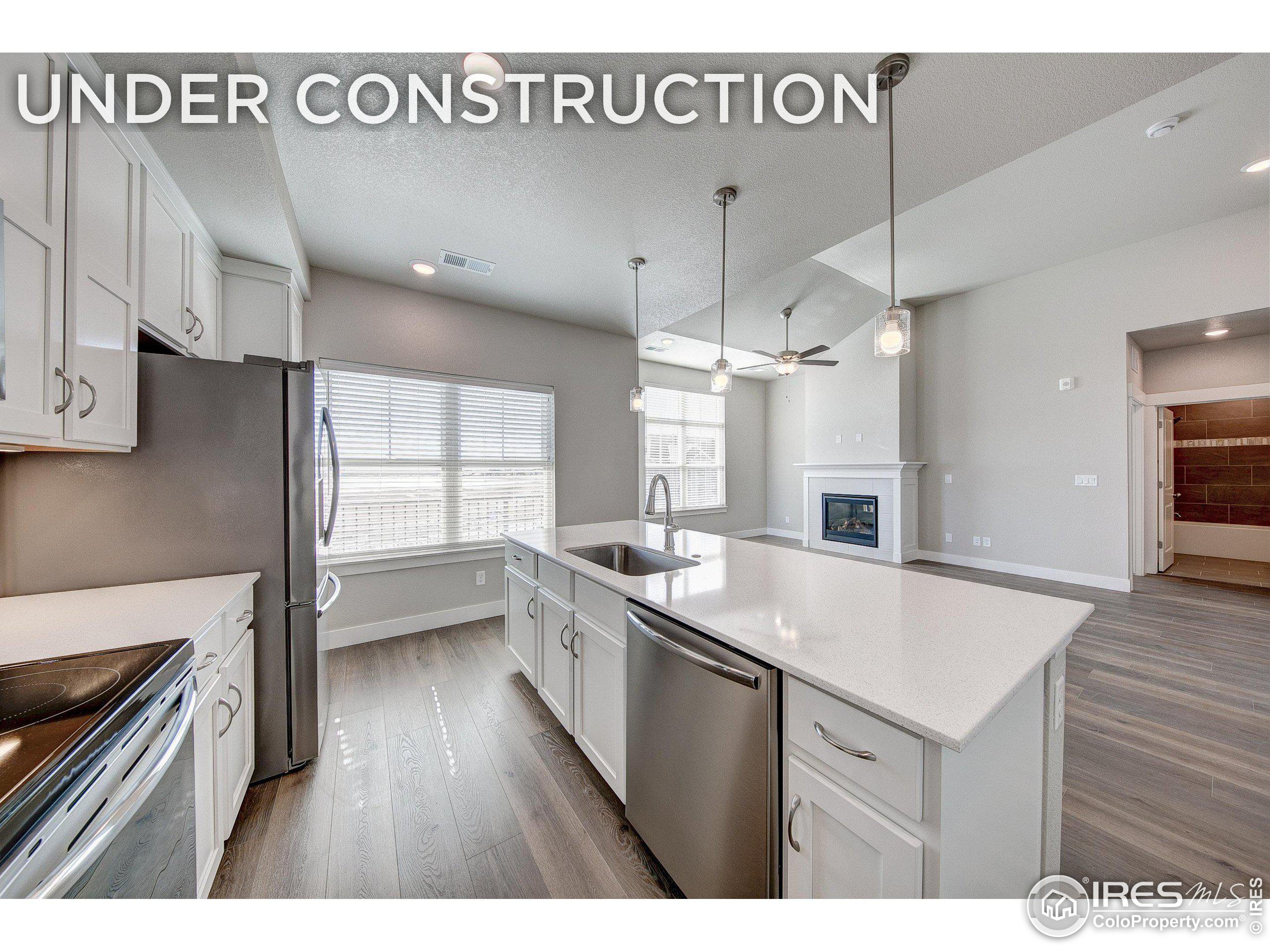 a kitchen with a sink appliances wooden floor and a window