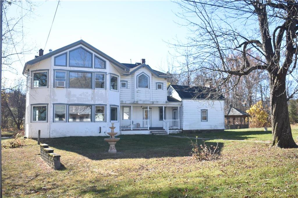 a front view of a house with a yard covered with snow