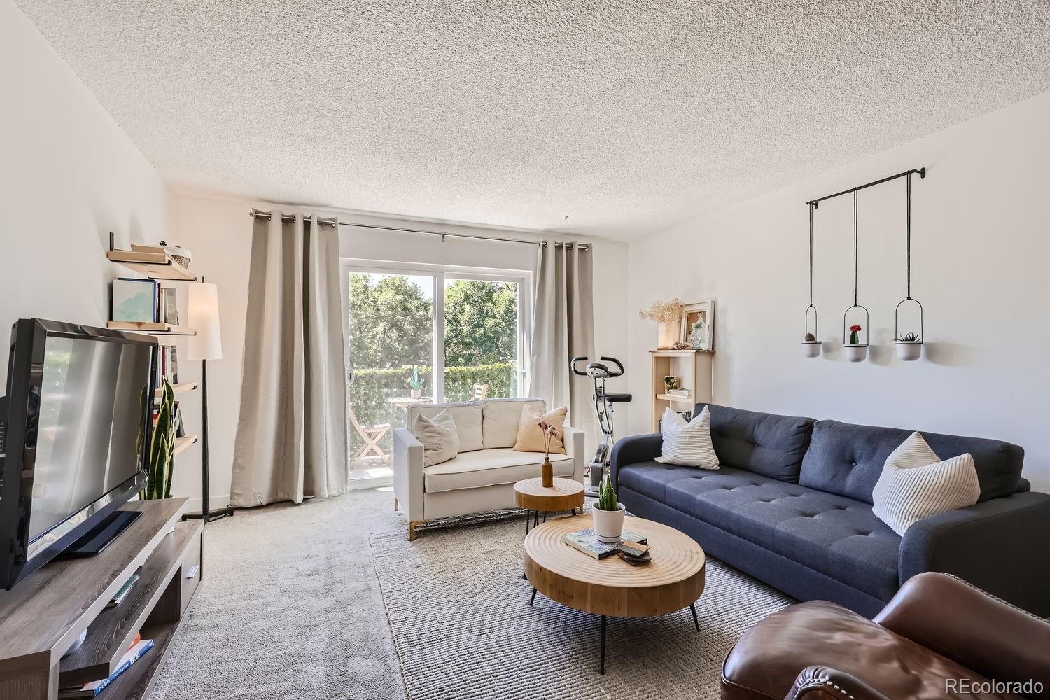 a living room with furniture a rug and a flat screen tv