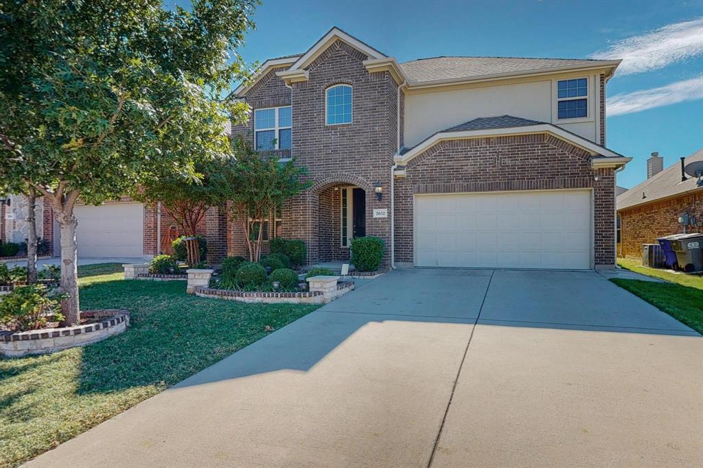 a front view of a house with a yard and a garage