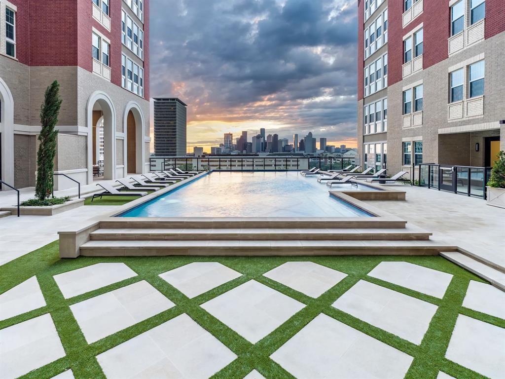 a view of pool with lawn chairs and plants