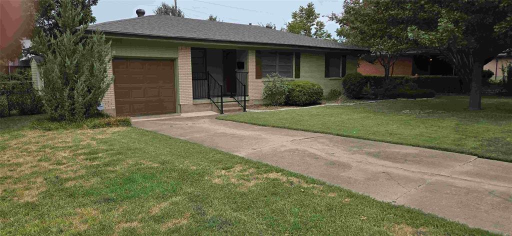 a front view of a house with a garden and plants