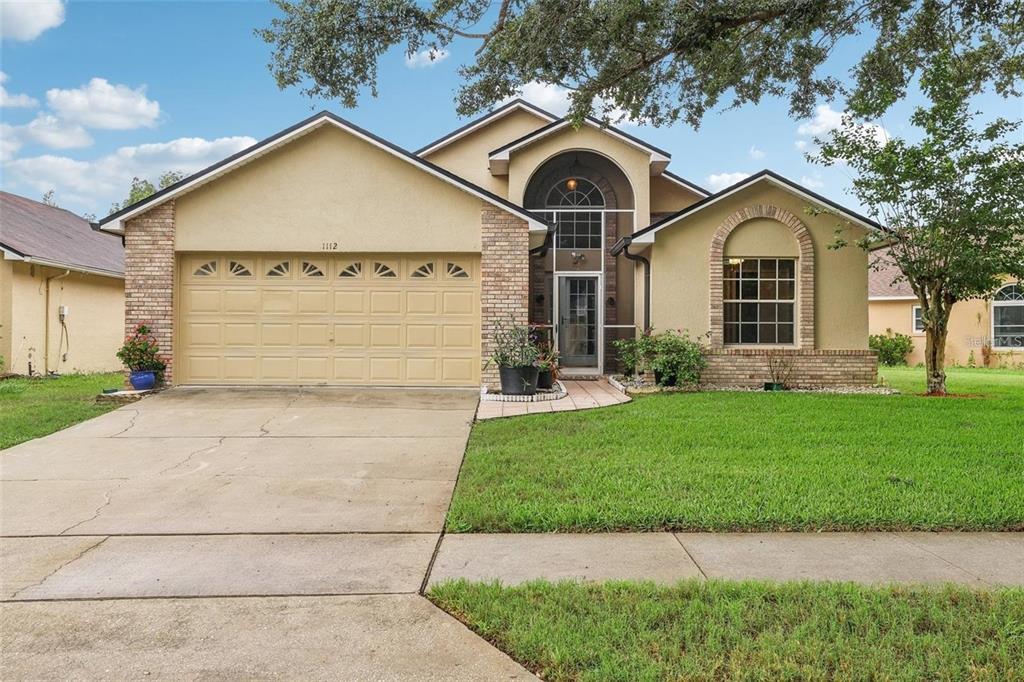 a front view of a house with a yard and garage