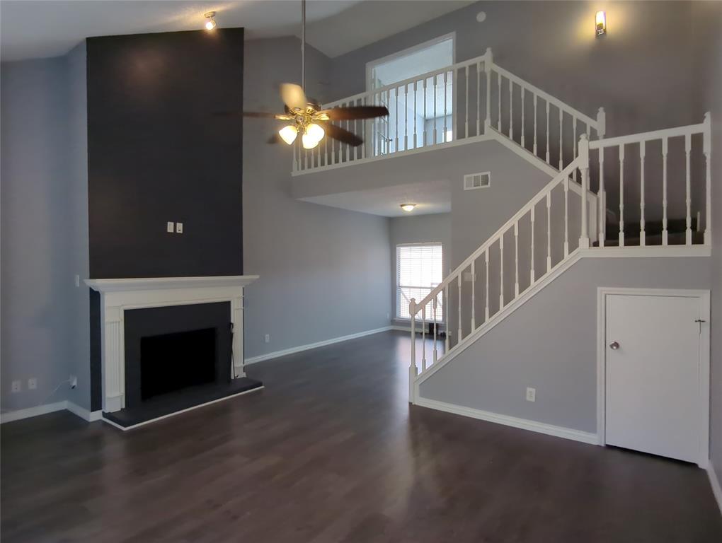 a view of an entryway with wooden floor windows and a fireplace