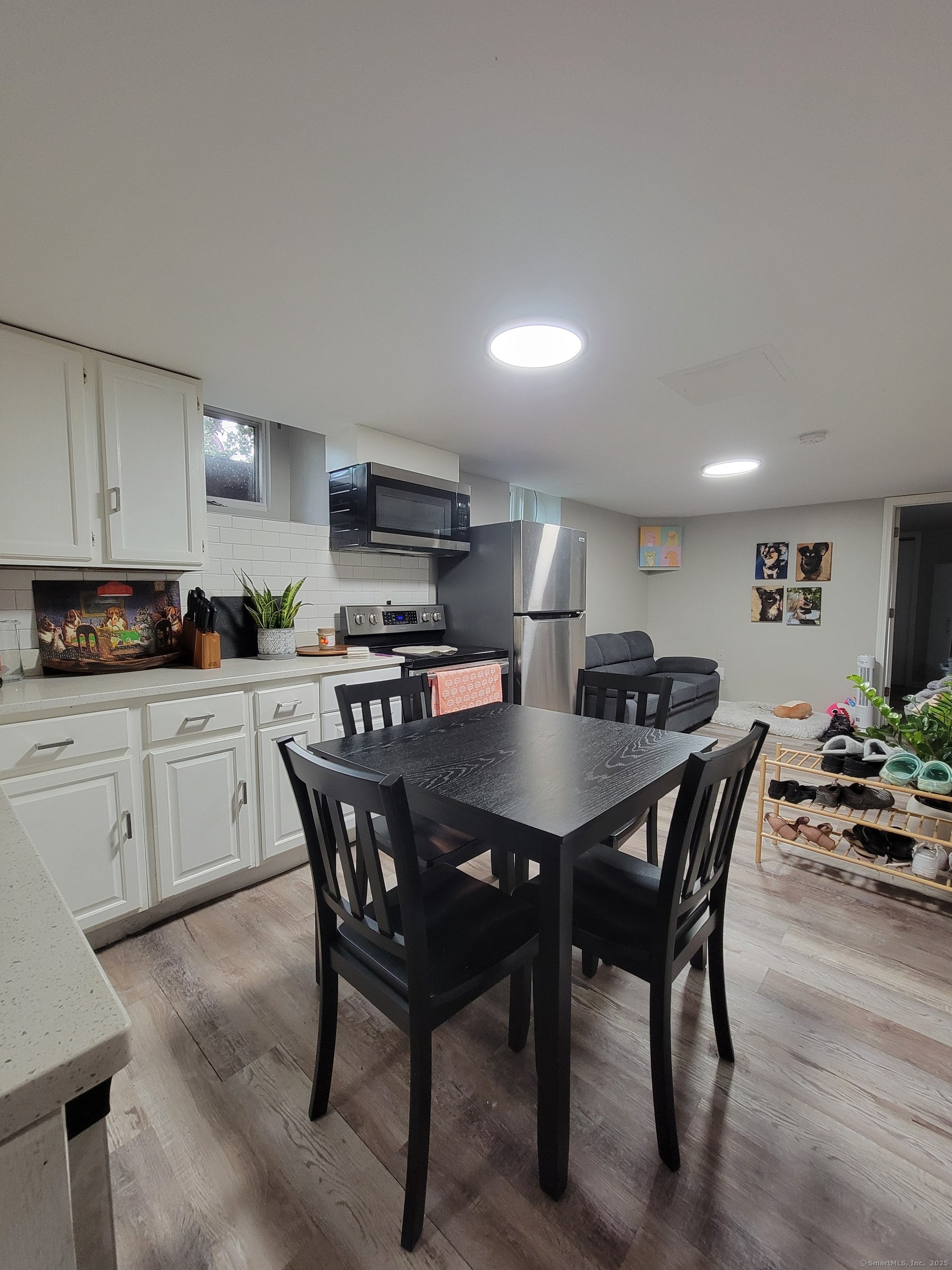 a kitchen with stainless steel appliances granite countertop a sink a stove a dining table and chairs