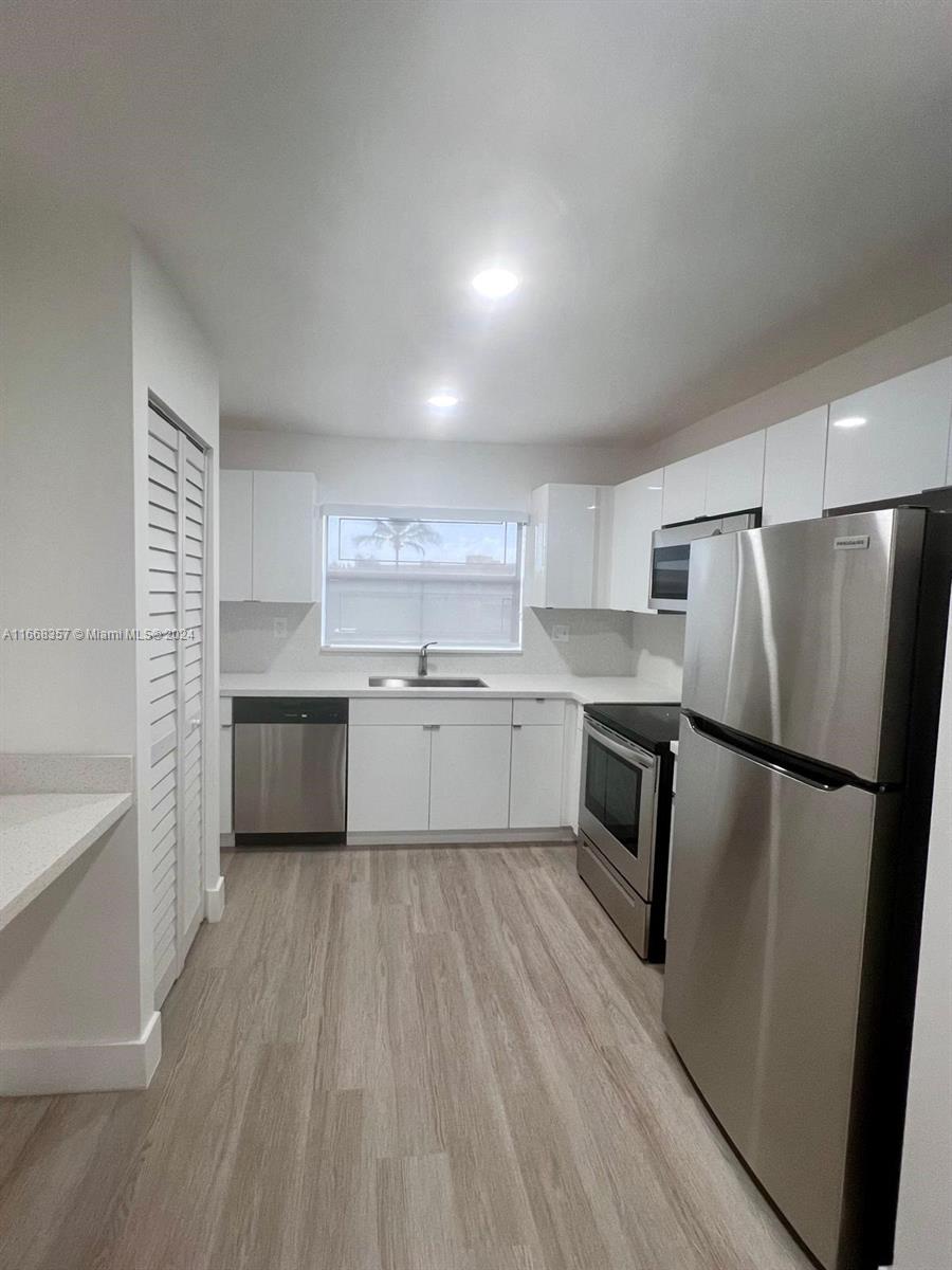 a kitchen with a refrigerator a sink and cabinets