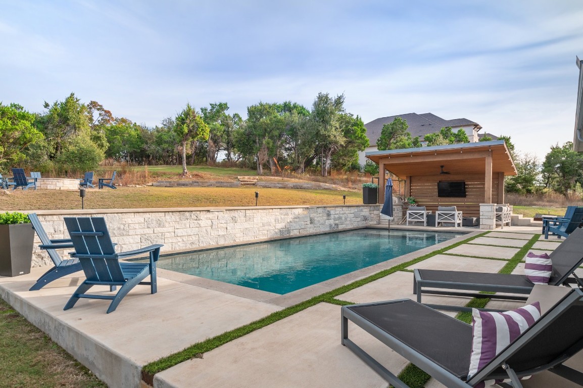 a view of a house with swimming pool and sitting area