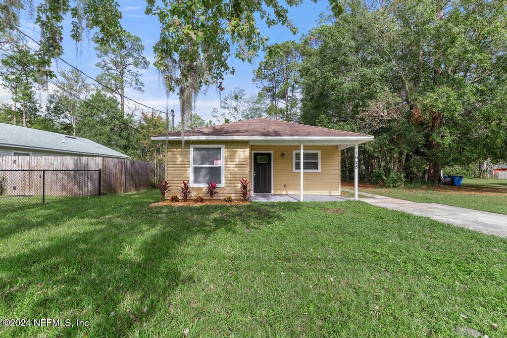 a view of a house with a yard and sitting area