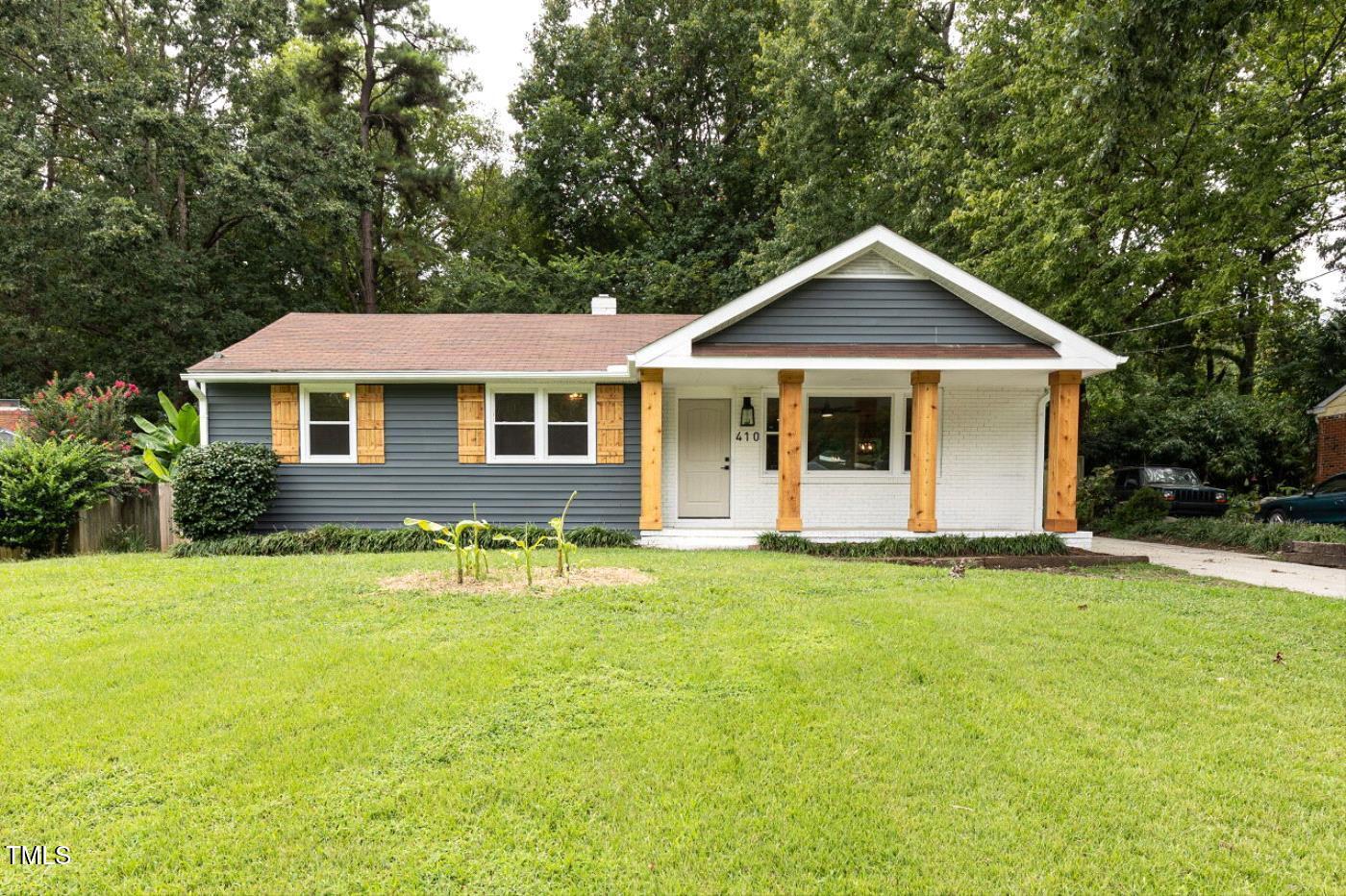 a front view of a house with yard and green space