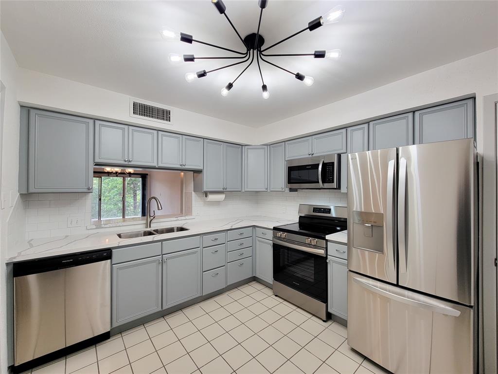 a kitchen with white cabinets stainless steel appliances and a center island