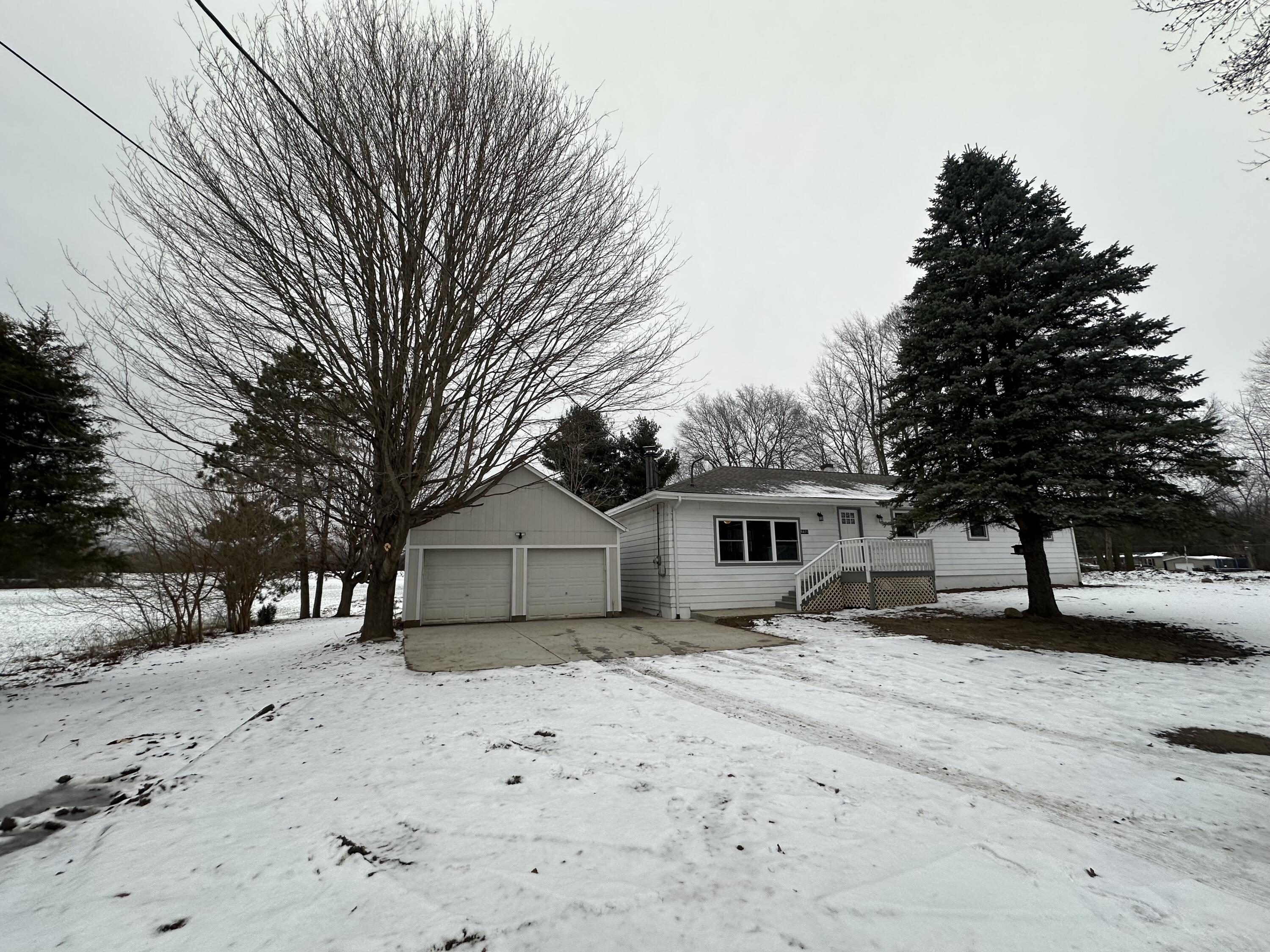 a front view of a house with a yard covered with snow