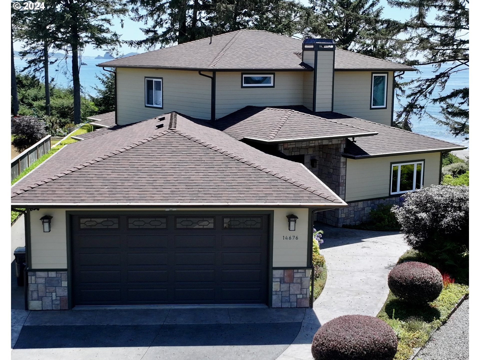 a front view of house with yard and trees in the background