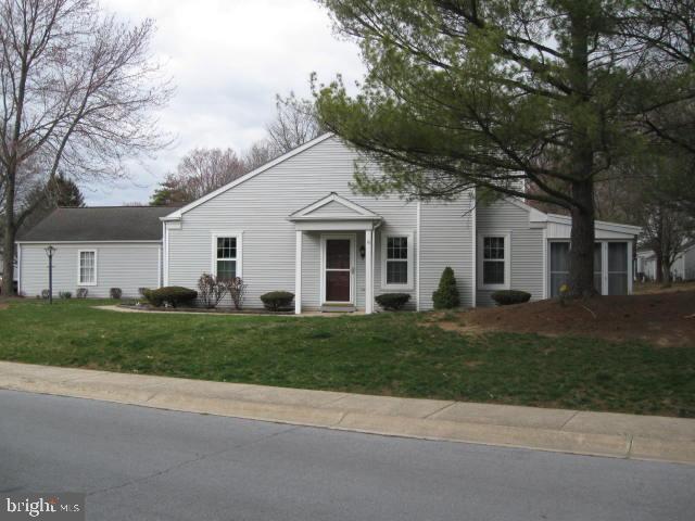 a front view of a house with a garden and trees