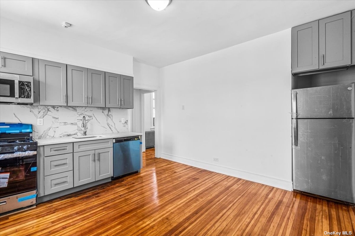 a kitchen with granite countertop wooden floors and white stainless steel appliances