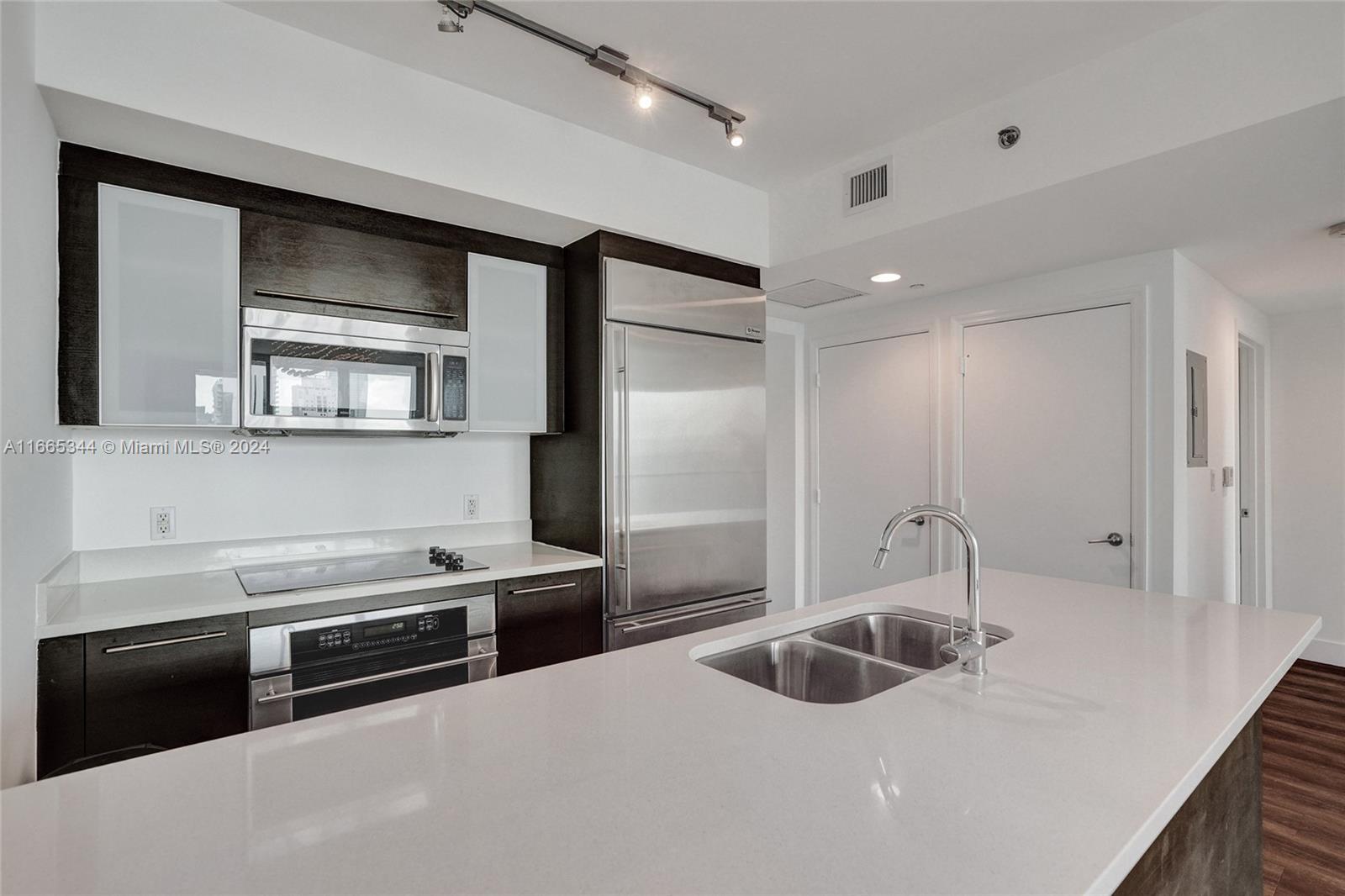 a kitchen with stainless steel appliances a sink stove and refrigerator