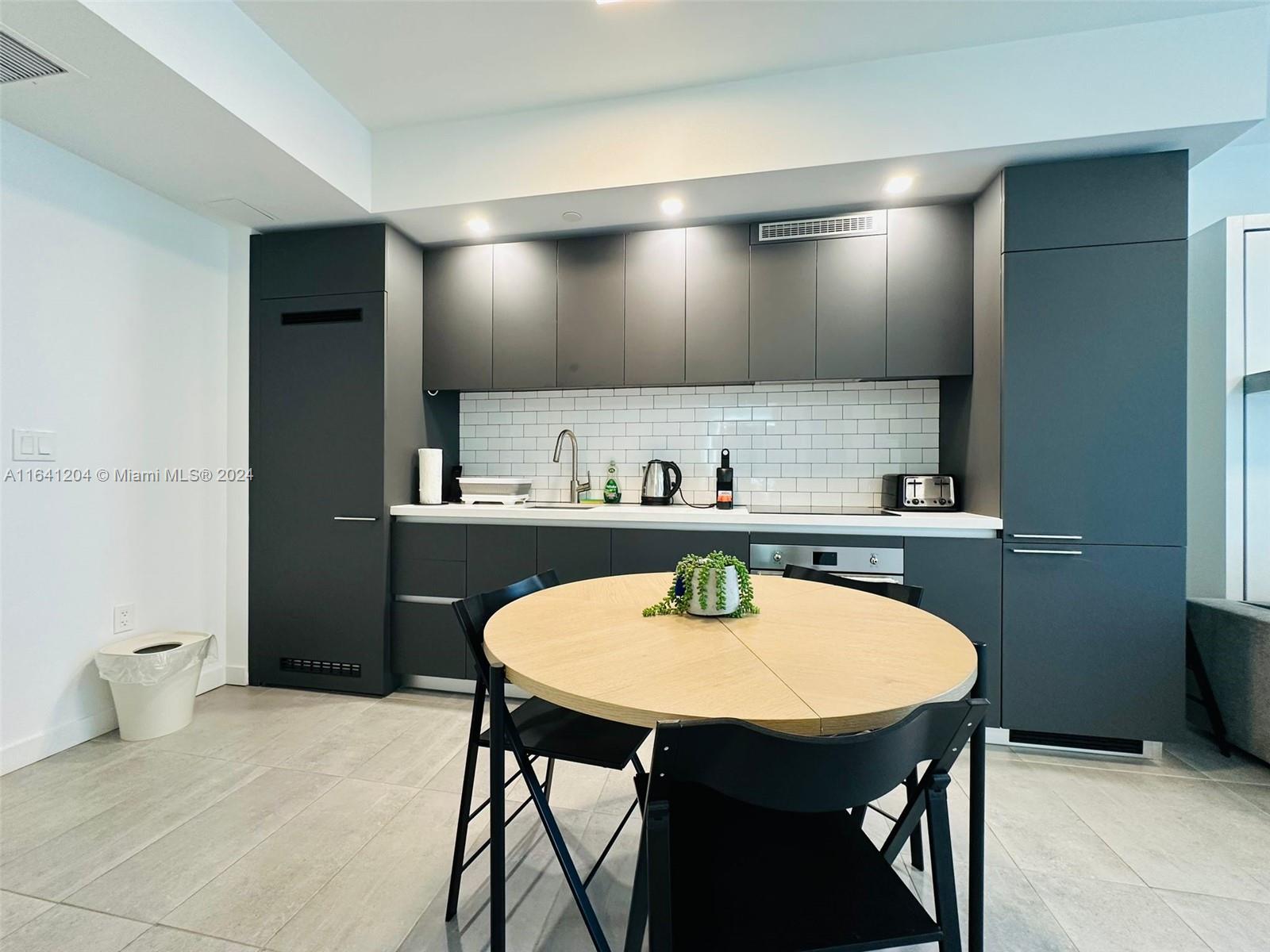 a kitchen with a table and chairs in it