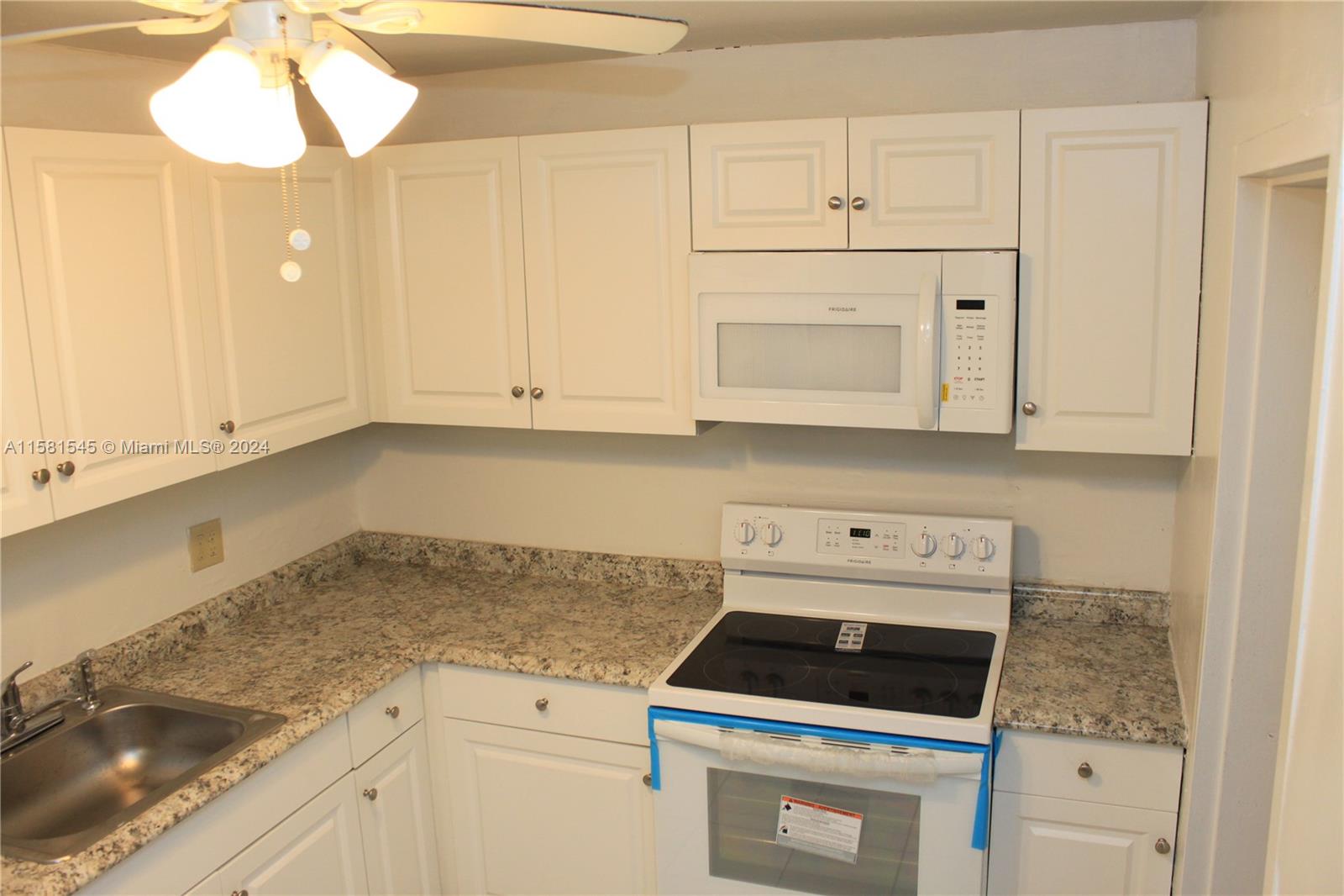 a kitchen with white cabinets and white appliances